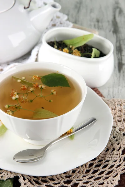 Kopje thee met linden op servetten op houten tafel — Stockfoto