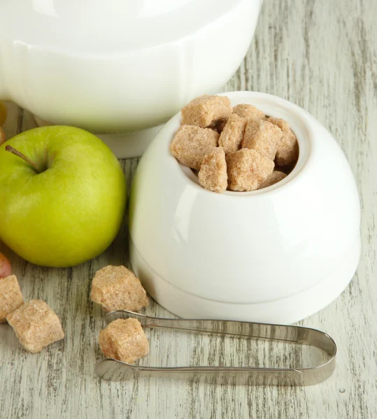 Unrefined sugar in white sugar bowl on wooden background — Stock Photo, Image