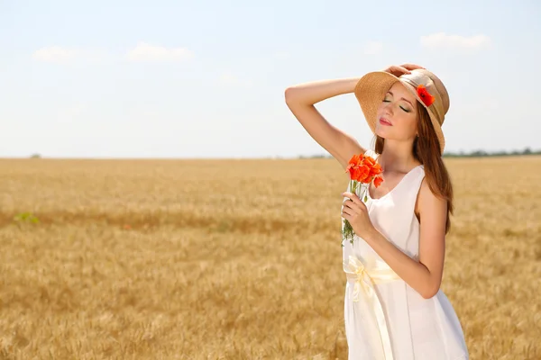 Retrato de una hermosa joven con amapolas en el campo —  Fotos de Stock