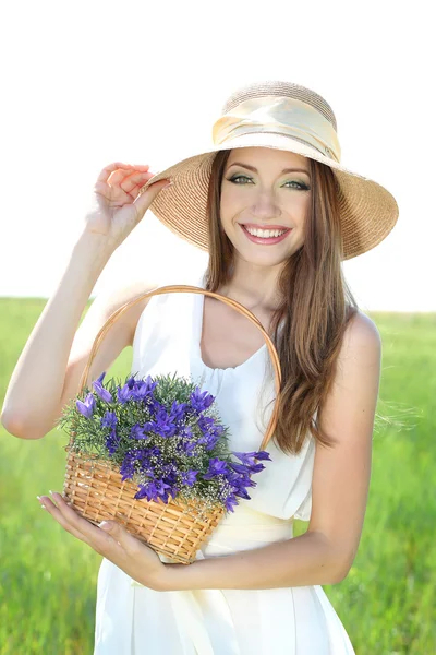 Retrato de bela jovem com flores no campo — Fotografia de Stock