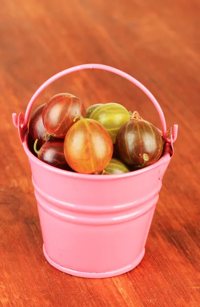 Frische Stachelbeeren im Eimer auf dem Tisch in Großaufnahme — Stockfoto