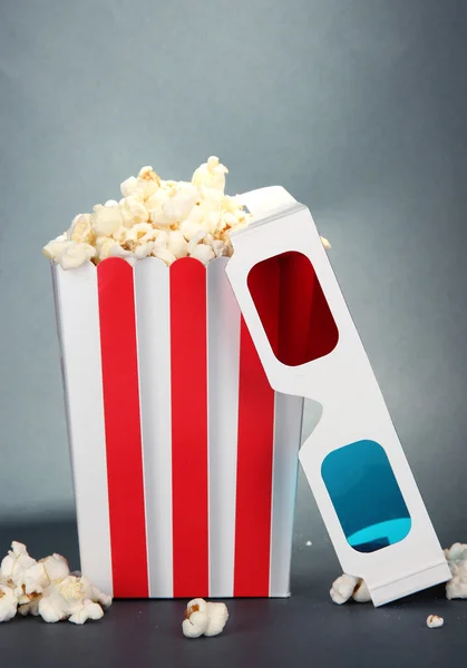 Popcorn and 3D glasses on grey background — Stock Photo, Image