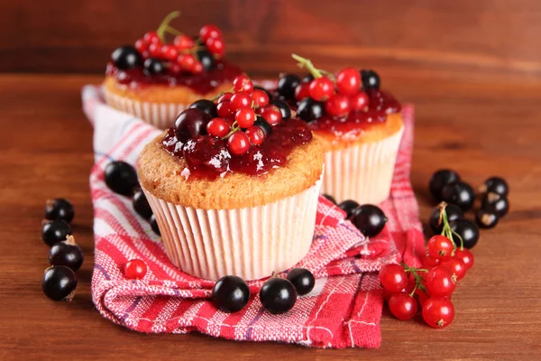 Tasty muffins with berries on wooden table — Stock Photo, Image