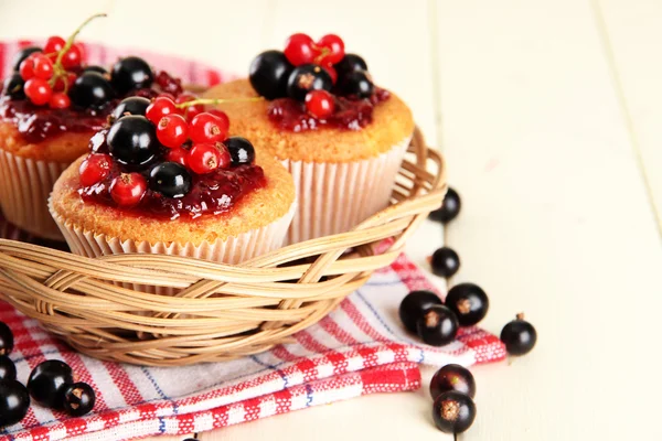 Leckere Muffins mit Beeren auf weißem Holztisch — Stockfoto
