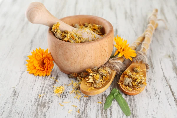 Frische und getrocknete Ringelblumen im Mörser auf Holzgrund — Stockfoto