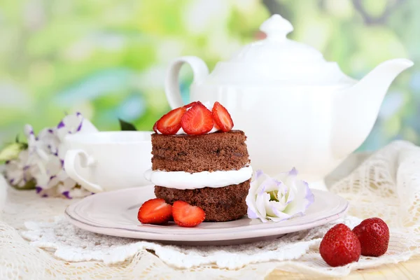 Chocolate cake with strawberry on wooden table on natural background — Stock Photo, Image