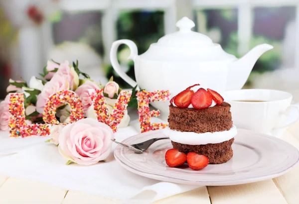 Schokoladenkuchen mit Erdbeere auf Holztisch auf Zimmerhintergrund — Stockfoto