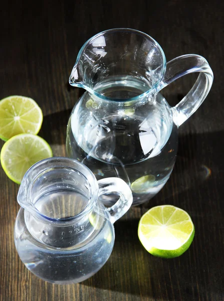 Glas kannor vatten på träbord närbild — Stockfoto