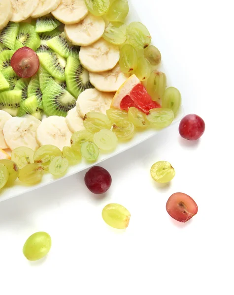 Assortment of sliced fruits on plate, isolated on white — Stock Photo, Image