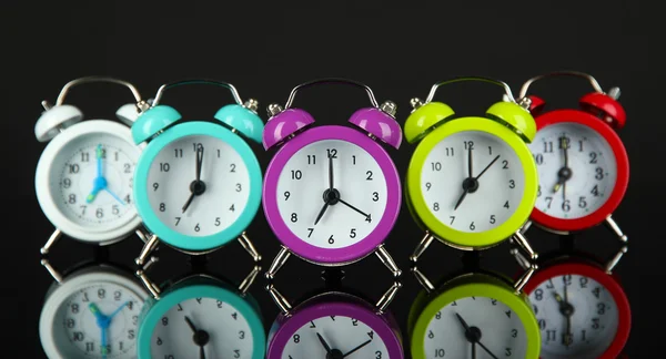 Relógio de alarme colorido no fundo cinza escuro — Fotografia de Stock