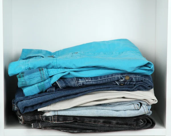 Clothes neatly folded on shelves — Stok fotoğraf