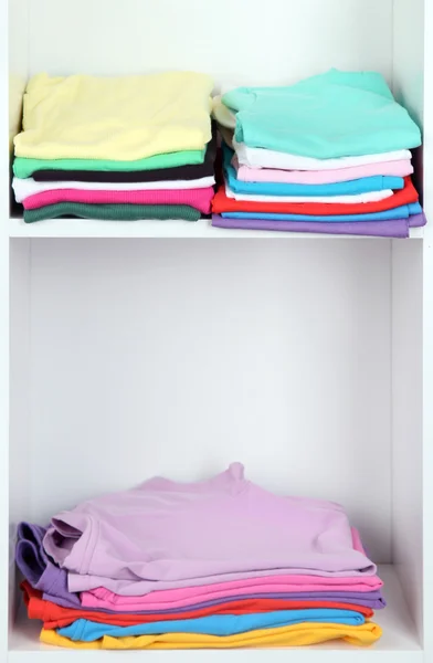 Clothes neatly folded on shelves — Stockfoto