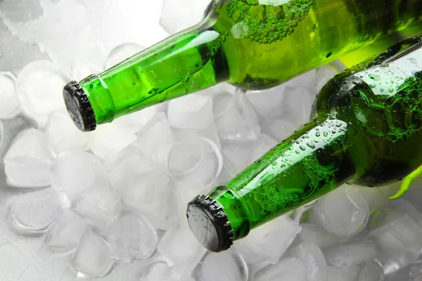 Bottles of beer with ice cubes, close up — Stock Photo, Image