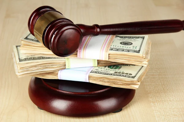 Stacks of money and judges gavel on wooden table — Stock Photo, Image