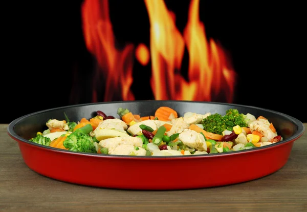 Tencere tava, yangın arka plan üzerinde et ve sebze ile — Stok fotoğraf