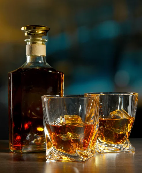 Glass of whiskey with bottle, on dark background — Stock Photo, Image