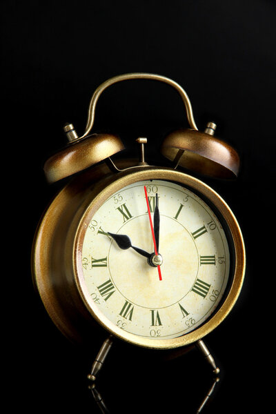 Old alarm clock isolated on black