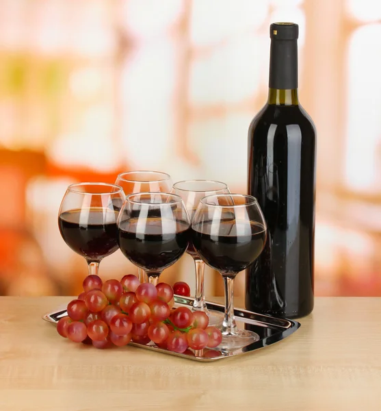 Vino tinto en vaso y botella sobre fondo de habitación — Foto de Stock