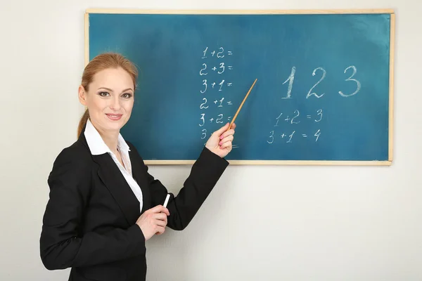 Portrait of teacher woman near chalkboard in classroom — Stock Photo, Image