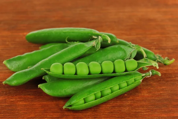 Guisantes verdes dulces sobre fondo de madera —  Fotos de Stock