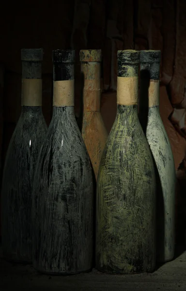 Viejas botellas de vino en bodega vieja, sobre fondo oscuro —  Fotos de Stock