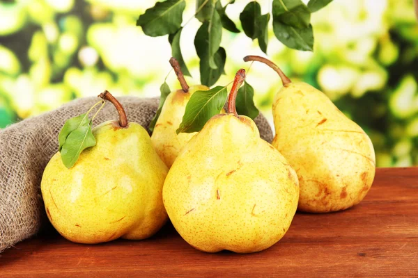 Juicy pears on table on bright background