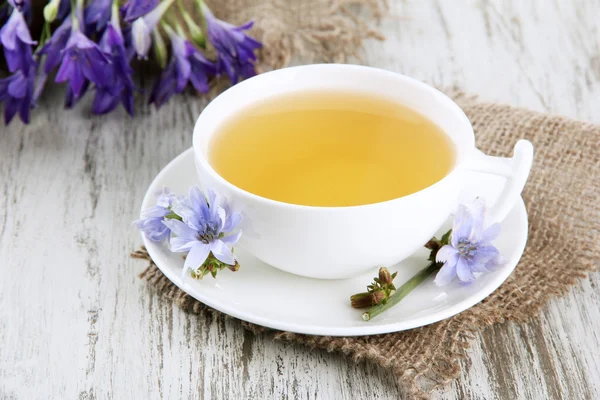 Taza de té con achicoria, sobre fondo de madera — Foto de Stock