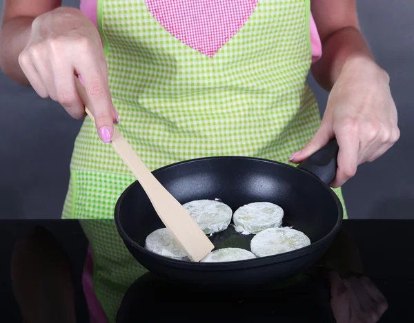 Manos cocinando calabacines en sartén sobre fondo gris — Foto de Stock