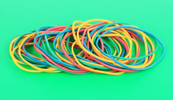 Colorful rubber bands on green background — Stock Photo, Image