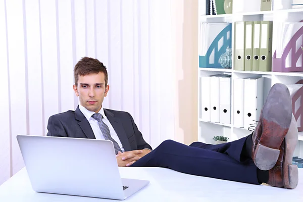 Podnikatel spočívající v jeho kanceláři s botama na stole — Stock fotografie