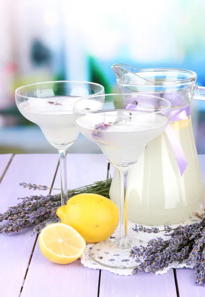 Lavendellimonade in Glaskanne und Cocktailgläsern, auf hellem Hintergrund — Stockfoto