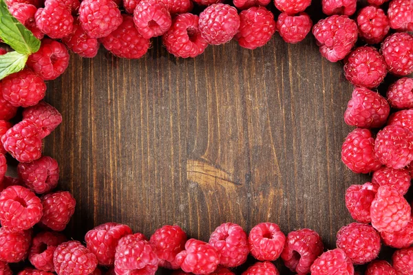 Framboises sucrées mûres sur fond de bois — Photo