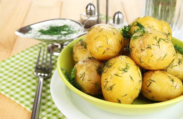 Boiled potatoes on platens on on napkins on wooden table — Stock Photo, Image