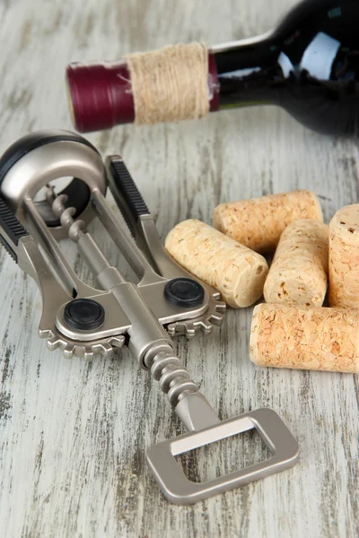 Korkenzieher mit Weinkorken und Flasche Wein auf Holztisch in Großaufnahme — Stockfoto
