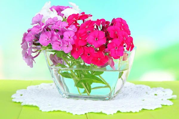 Piękny bukiet kwiaty domowe w misce na stole na jasnym tle — Zdjęcie stockowe