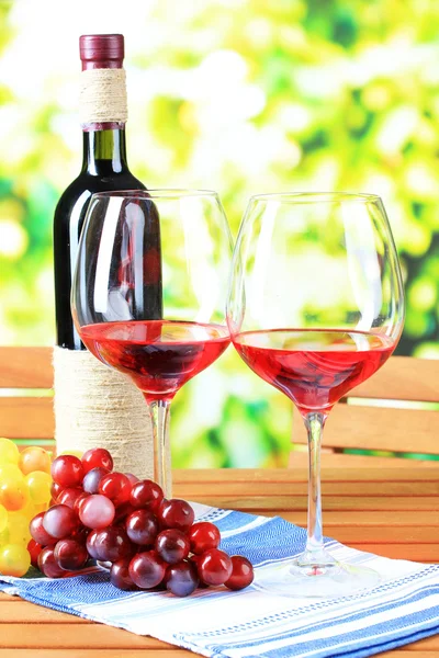 Glas vin på servett på träbord på natur bakgrund — Stockfoto