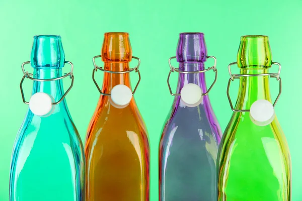 緑の背景にカラフルなボトル — ストック写真