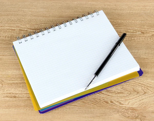 Notebook e caneta na mesa de madeira — Fotografia de Stock