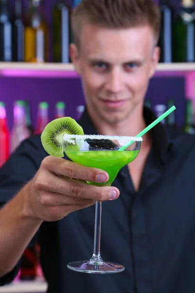 Portrét hezký barman připravuje koktejlu v baru — Stock fotografie