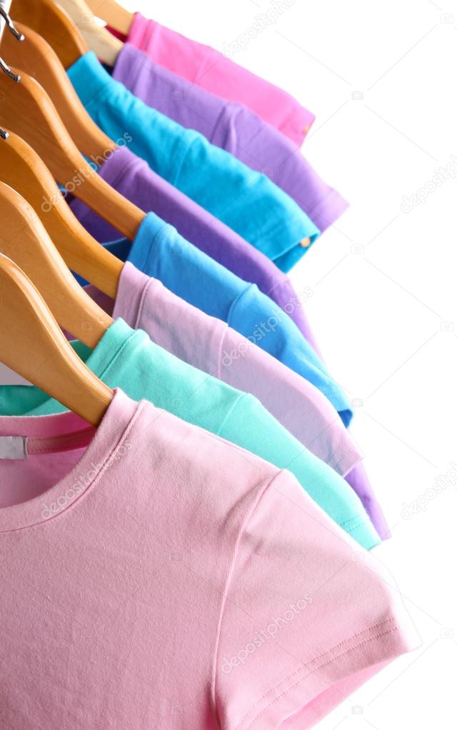 Lots of T-shirts on hangers isolated on white