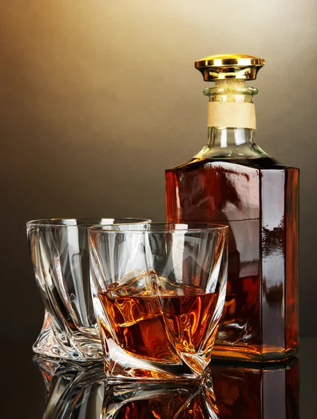 Glass of whiskey with bottle, on dark background — Stock Photo, Image