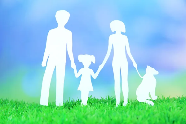 Familie aus Papier auf Gras auf hellem Hintergrund — Stockfoto