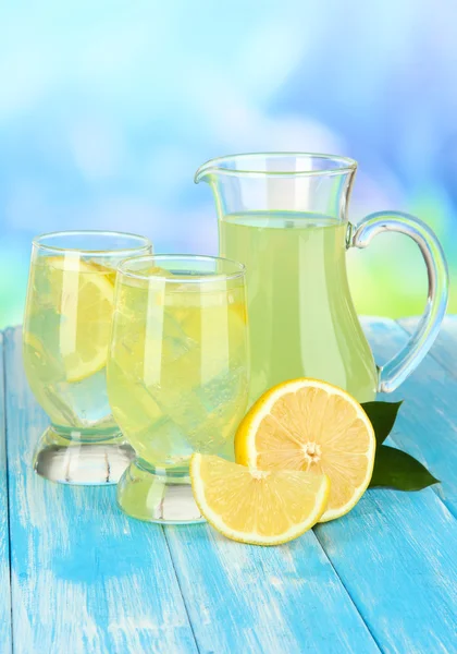 Délicieuse limonade sur table sur fond bleu — Photo