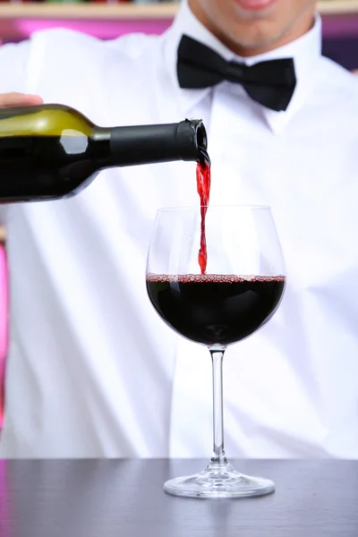 Бармен наливает красное вино в бокал — стоковое фото