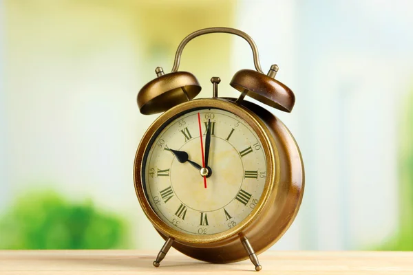 Old alarm clock on bright background — Stock Photo, Image