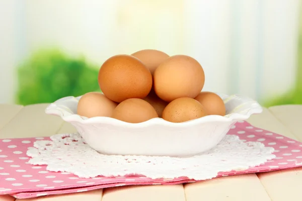 Eier im Teller auf Holztisch auf natürlichem Hintergrund — Stockfoto