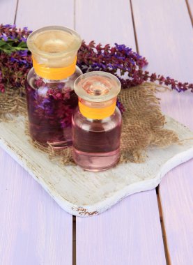 Ada çayı çiçekler mor ahşap zemin ile ilaç şişeleri