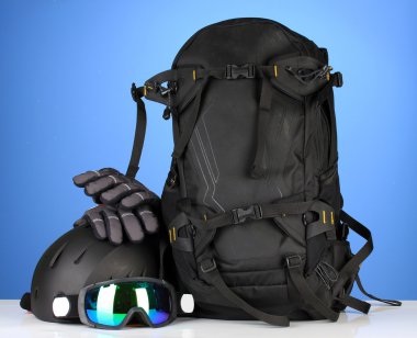 kış spor gözlük, kask ve eldivenler, sırt çantası, mavi zemin üzerine