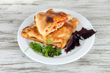 Pizza calzones tabakta ahşap masa üzerinde