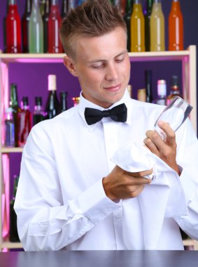 Barmen gözlük iş yerinde siliyor.